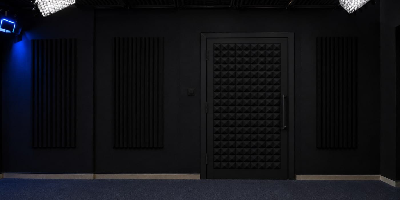 The studio’s acoustic door, lined with foam panels, between acoustic wall panels