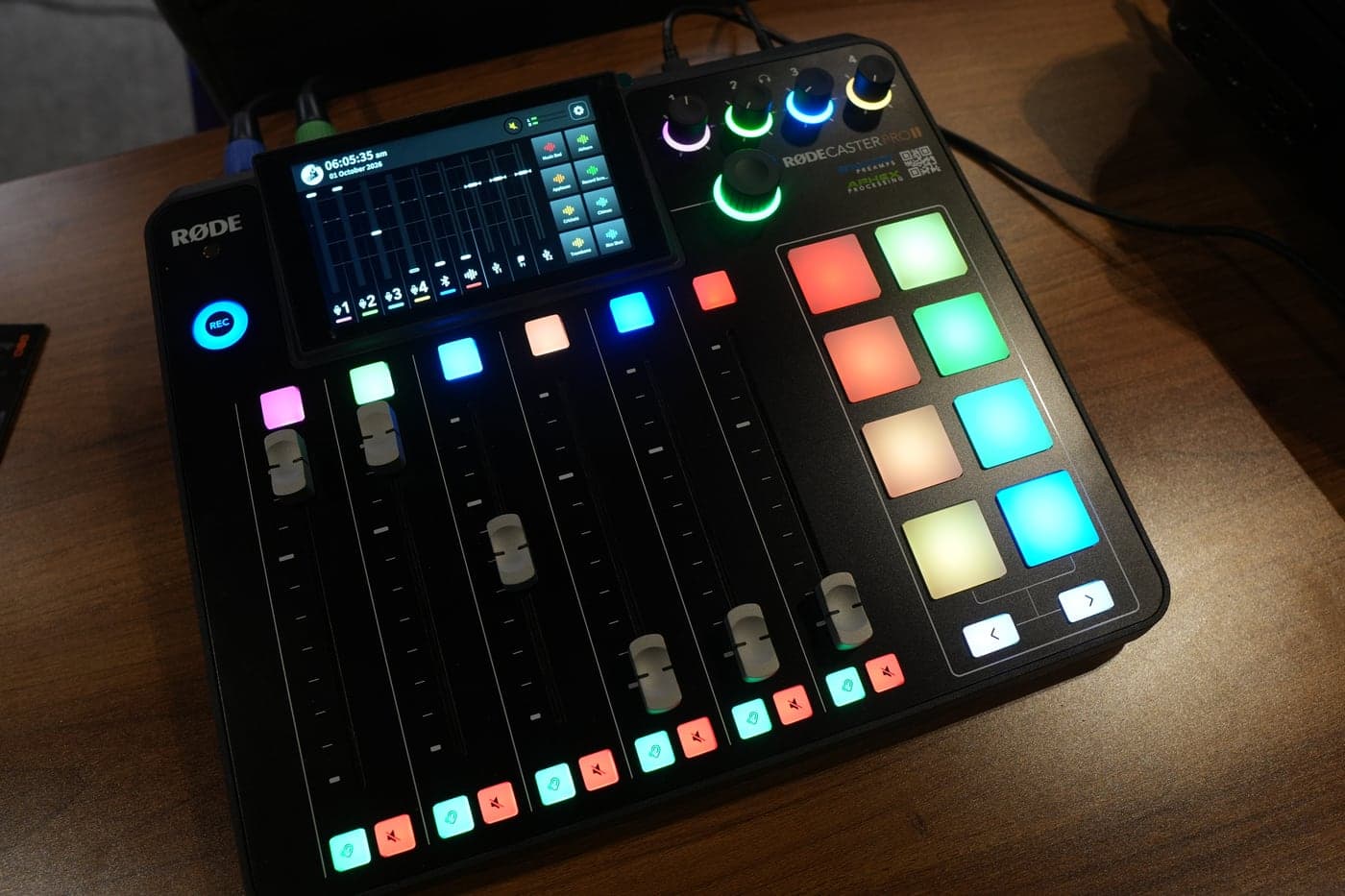 The RØDECaster Pro II sound desk, its pads and faders lit